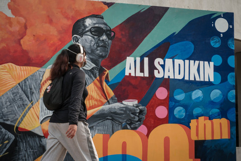Warga berjalan melintasi mural bergambar mantan Gubernur DKI Jakarta Ali Sadikin di kawasan Taman Ismail Marzuki (TIM), Cikini, Jakarta, Minggu (19/7/2026). Foto: Iqbal Firdaus/kumparan