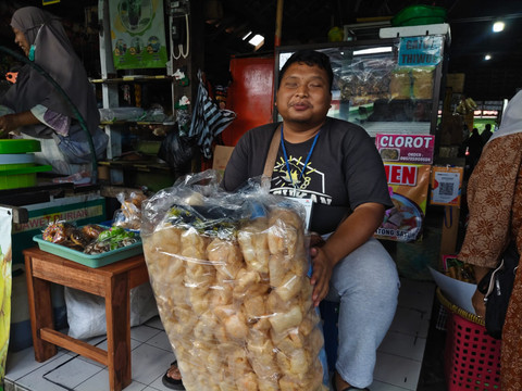 pGilang Rizki (29) difabel tunanetra lulusan UIN Sunan Kalijaga berjualan kerupuk rambat karena sudahnya cari pekerjaan kantoran. Menjadi pedagang asongan juga penuh rintangan bagi pria kelahiran Brebes, Jawa Tengah itu, Rabu (22/7/2026). Foto: Arfiansyah Panji Purnandaru/kumparan