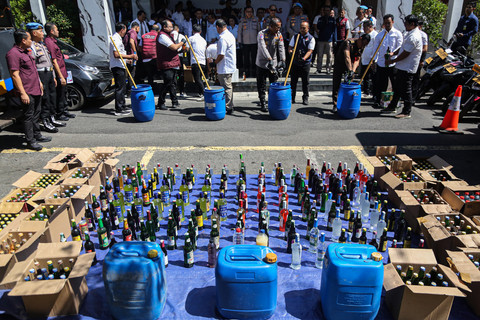Petugas gabungan membuang minuman beralkohol ilegal saat rilis pemusnahan barang bukti narkotika dan minuman keras (miras) ilegal di Mapolda Jawa Tengah, Semarang, Jawa Tengah, Rabu (22/7/2026). Foto: Makna Zaezar/ANTARA FOTO