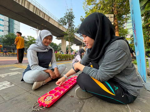 Dian (22) warga Mampang, Jakarta Selatan dan Nabila (21) warga Kemang, Jakarta Selatan, saat bermain permainan tradisional di kawasan CFD Rasuna Said, Jakarta Selatan, Minggu (26/7/2026). Foto: Nauval Pratama/kumparan