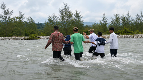 Sejumlah pelajar harus menyeberangi sungai untuk berangkat ke sekolah karena belum tersedianya akses yang layak di Desa Masungkang, Kecamatan Batui Selatan, Kabupaten Banggai, Sulawesi Tengah. Foto: Dok. Istimewa