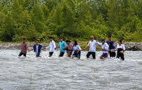 Sejumlah pelajar harus menyeberangi sungai untuk berangkat ke sekolah karena belum tersedianya akses yang layak di Desa Masungkang, Kecamatan Batui Selatan, Kabupaten Banggai, Sulawesi Tengah. Foto: Dok. Istimewa