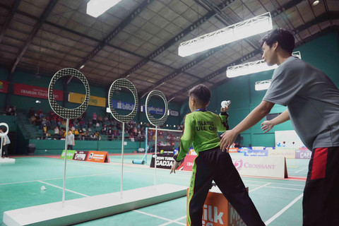 Peserta MilkLife Festival SenengMinton Magelang 2026 melakukan tantangan Throwing The Shuttlecock yakni melempar kok ke dalam lubang target.
Foto: Dok. MilkLife