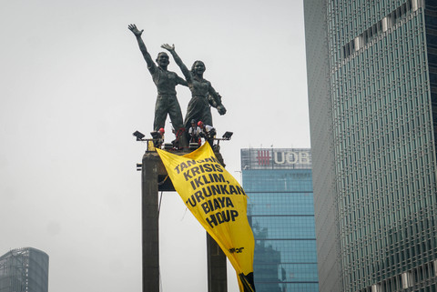 Aktivis lingkungan hidup Greenpeace Indonesia menggelar aksi damai dan membentangkan spanduk raksasa di atas Patung Selamat Datang (Monumen Selamat Datang), Bundaran HI, Jakarta, Selasa (20/10/2026).
 Foto: Iqbal Firdaus/kumparan