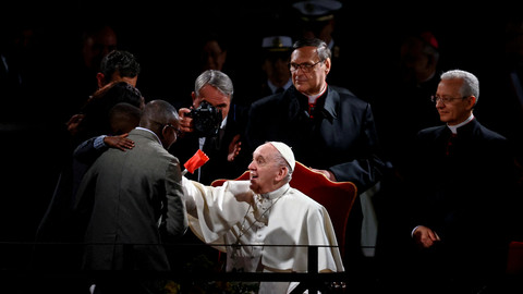Paus Fransiskus berbicara dengan keluarga migran menjelang prosesi Via Crucis (Jalan Salib) selama perayaan Jumat Agung di Colosseum, di Roma, Italia, Jumat (15/4/2022). Foto: Yara Nardi/REUTERS
