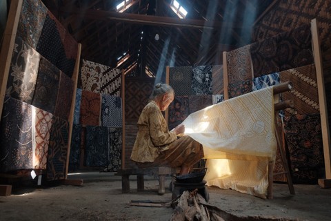 Proses pembuatan batik tulis tangan di atas kain dengan lilin yang dipanaskan. Foto: Asep Dwi Kurniawan/Shutterstock.
