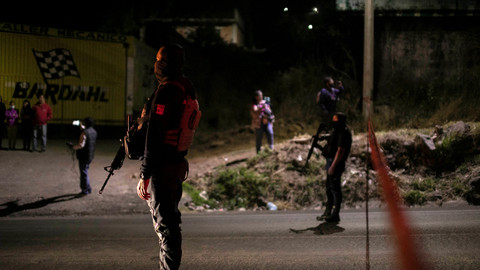 Polisi berjaga-jaga di tempat kejadian setelah bentrokan antar geng terjadi dalam serangan pembantaian di Zinapecuaro, Meksiko, Senin (28/3/2022) waktu setempat.
Foto: Stringer/REUTERS