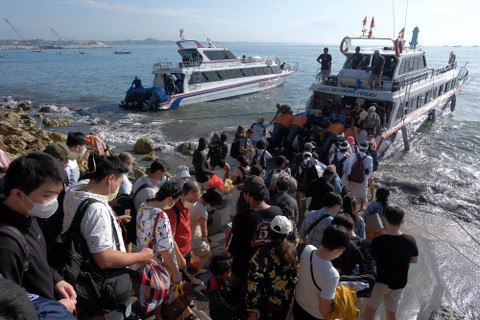 Wisatawan mengantre saat naik ke kapal cepat untuk menyeberang menuju Pulau Nusa Penida, di Pelabuhan Sanur, Denpasar, Bali, Jumat (15/4/2022). Foto: ANTARA FOTO/Nyoman Hendra Wibowo
