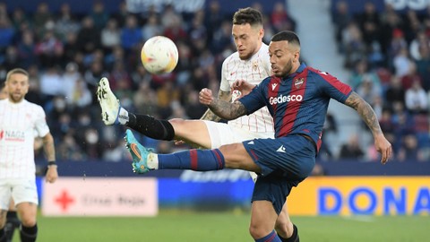 Bek Levante Ruben Vezo beraksi dengan pemain Sevilla Lucas Ocampos di Stadion Ciutat de Valencia di Valencia, Kamis (21/4/2022). Foto: Jose Jordan/AFP