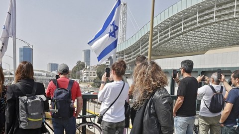Warga Israel berdiri mengheningkan cipta saat sirene bergema selama dua menit menandai Hari Peringatan Holocaust tahunan di Tel Aviv pada Kamis (28/4/2022). Foto: Jack Guez/AFP