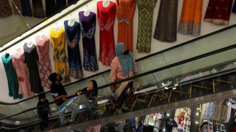 Pengunjung pusat perbelanjaan di Malaysia menaiki eskalator. Foto: Hasnoor Hussain/REUTERS