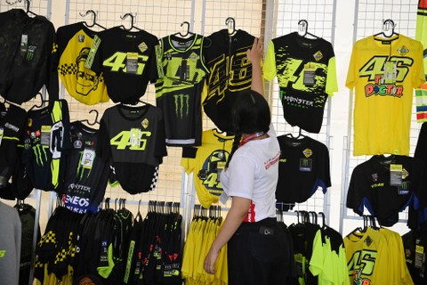 Penjual menata kaus VR46 yang merupakan merek apparel milik legenda MotoGP Valentino Rossi di Pertamina Mandalika International Street Circuit, Lombok Tengah, NTB. Foto: Andika Wahyu/Antara Foto