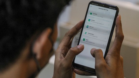 Nasabah mengecek aplikasi untuk melihat dana Jaminan Hari Tua (JHT) di Kantor BPJS Ketenagakerjaan cabang Sudirman, Jakarta, Senin (14/2/2022). Foto: Asprilla Dwi Adha/Antara Foto