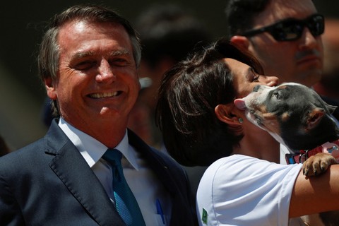 Presiden Brasil Jair Bolsonaro di sebelah istrinya Michelle Bolsonaro, dalam upacara penyambutan untuk menerima warga Brasil dan orang asing yang dievakuasi dari Ukraina di Pangkalan Udara Brasilia, di Brasilia, Brasil (10/3). Foto: Adriano Machado/REUTERS