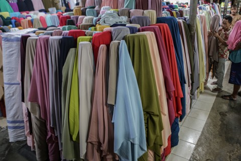 Seorang pedagang menata kain tekstil dagangannya di Cipadu, Kota Tangerang, Banten, Selasa (22/2/2022). Foto: Fauzan/ANTARA FOTO
