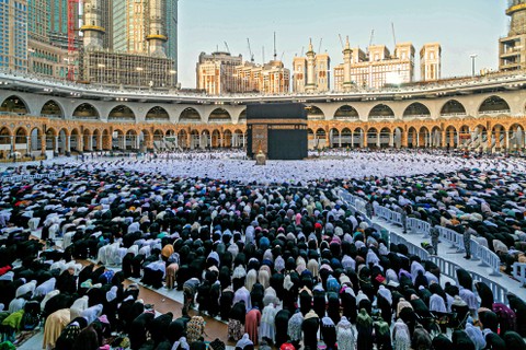Umat Muslim Salat Id di Masjidil Haram di kota suci Mekkah Arab Saudi untuk menghadiri sholat Idul Fitri, hari libur Muslim yang dimulai pada akhir bulan suci Ramadhan, Senin (2/5/2022). Foto: Abdel Ghani Bashir/AFP