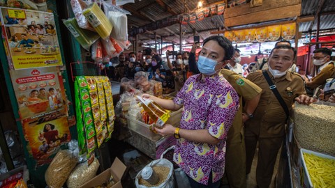 Wakil Menteri Perdagangan Jerry Sambuaga memegang minyak goreng saat meninjau ketersediaan barang kebutuhan pokok di Pasar KM 5 Palembang, Sumatera Selatan, Senin (28/3/2022). Foto: Nova Wahyudi/ANTARA FOTO
