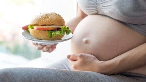 Ibu hamil makan burger. Foto: Artem Oleshko/Shutterstock