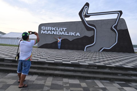 Wisatawan berfoto di depan tulisan dan lambang sirkuit Mandalika di kompleks Pertamina Mandalika International Street Circuit, Lombok Tengah, NTB, Senin (21/3/2022). Foto: Andika Wahyu/ANTARA FOTO