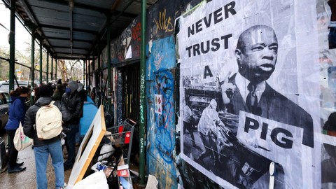 Poster Walikota New York City Eric Adams terlihat di sebelah perkemahan para tunawisma di East 9th Street di Manhattan, New York City, AS, Rabu (6/4/2022). Foto: Andrew Kelly/REUTERS