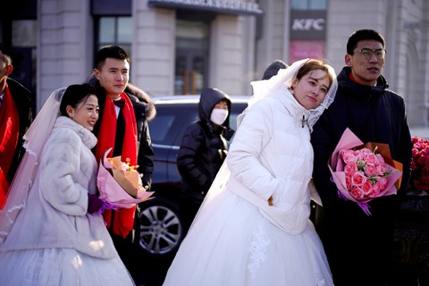 Pasangan pengantin baru menghadiri upacara pernikahan massal pada festival es tahunan di kota utara Harbin, provinsi Heilongjiang, China, Minggu (5/1). Foto: REUTERS/Aly Song