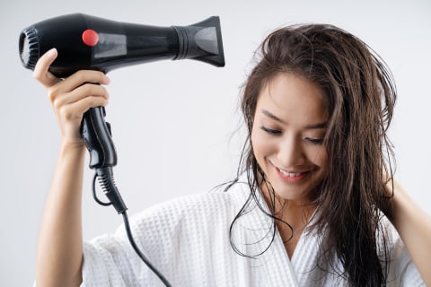 Ilustrasi mengeringkan rambut menggunakan hair dryer  Foto: Shutterstock