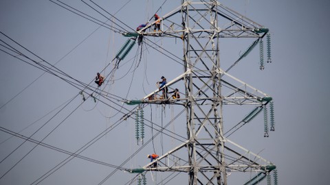 Pekerja memasang instalasi listrik di menara Saluran Udara Tegangan Ekstra Tinggi (SUTET) di arteri Porong, Sidoarjo, Jawa Timur, Senin (15/7/2019). Foto: Antara Foto/Umarul Faruq