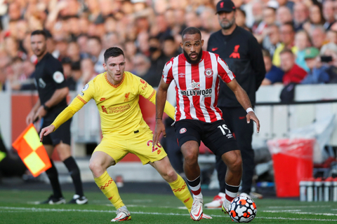 Pemain Brentford Bryan Mbeumo beraksi dengan pemain Liverpool Andrew Robertson di Brentford Community Stadium, London, Inggris, Sabtu (25/9). Foto: Action Images via Reuters/Matthew Childs