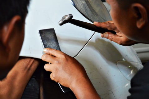 Pengerjaan ketok halus yang dilakukan tukang dan kenek ketok magic. Foto: Bagas Putra Riyadhana