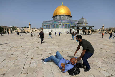 Sejumlah warga berlari selama bentrokan dengan warga Palestina di kompleks Masjid Al-Aqsa di Yerusalem.  Foto: Ammar Awad/REUTERS