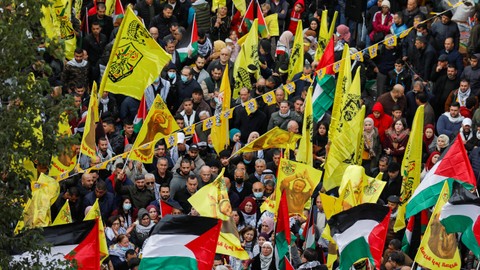 Warga Palestina menghadiri rapat umum yang menandai peringatan 57 tahun yayasan gerakan Fatah, di Ramallah, di Tepi Barat yang diduduki Israel 30 Desember 2021. Foto: REUTERS/Mohamad Torokman