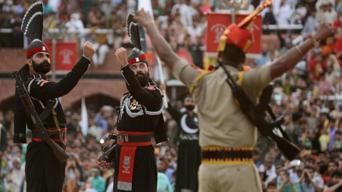 Personel Pasukan Keamanan Perbatasan Pakistan (baju hitam) dan Pasukan India (baju cokelat) dalam upacara Pemukulan Beating di Kashmir, Kamis (15/8). Foto: Kashmir