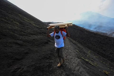 Chef David Garcia membawa alat untuk membuat pizza di gunung berapi Pacaya di Guatemala.   Foto: Johan Ordonez/AFP