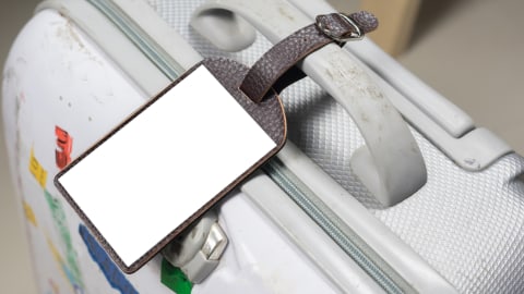 Ilustrasi koper bagasi dengan tag nama. Foto: Shutterstock