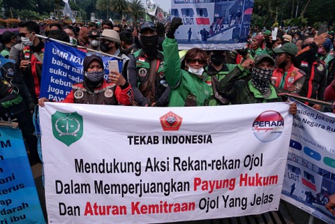 Massa gabungan dari Ojek online (Ojol) melakukan unjuk rasa di luar kawasan Monumen Nasional, Jakarta, Rabu (5/1/2022). Foto: Jamal Ramadhan/kumparan