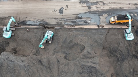 Pekerja mengoperasikan alat berat saat bongkar muat batu bara ke dalam truk di Pelabuhan PT Karya Citra Nusantara (KCN), Marunda, Jakarta, Rabu (12/1/2022). Foto: M Risyal Hidayat/ANTARA FOTO