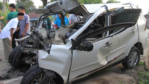 Sejumlah warga melihat mobil minibus yang ringsek setelah bertabrakan dengan mobil bus. Foto: ANTARA FOTO/Syifa Yulinnas
