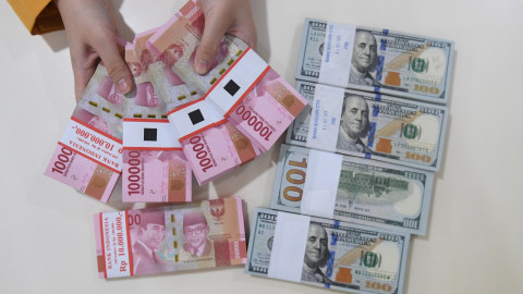 Seorang Teller menghitung uang Rupiah dan Dolar Amerika Serikat di Bank Mandiri, Jakarta, Senin (7/1/2018). Rupiah ditutup menguat 1,26 persen menjadi Rp14.085 per satu Dolar AS. Foto: ANTARA FOTO/Akbar Nugroho Gumay