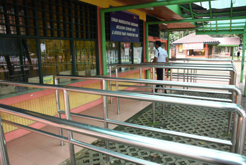 Petugas keamanan melintas di depan loket karcis masuk Taman Margasatwa Ragunan yang ditutup operasionalnya di Jakarta, Sabtu (21/3/2020). Foto: ANTARA FOTO/Indrianto Eko Suwarso