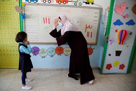 Seorang guru Palestina menggunakan bahasa isyarat saat memberikan pelajaran kepada siswa tunarungu di Sekolah Tunarungu al-Hanan, di Jenin, Tepi Barat yang diduduki Israel. Foto: RANEEN SAWAFTA/REUTERS