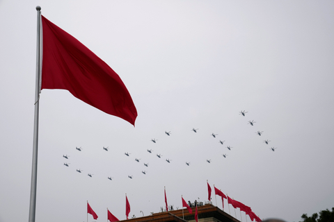 Helikopter terbang di atas bendera Tiongkok di Lapangan Tiananmen dalam formasi "100" selama upacara untuk menandai peringatan 100 tahun berdirinya Partai Komunis China di Lapangan Tiananmen di Beijing, China, Kamis (7/1). Foto: Ng Han Guan/AP Photo
