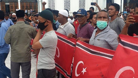Sejumlah orang memegang bendera Bulan-Bintang saat Milad Gerakan Aceh Merdeka (GAM), di Masjid Raya Baiturrahman Banda Aceh, Jumat (4/12). Foto: Dok. Istimewa