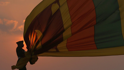 Anggota militer Sri Lanka berdiri disamping bendera nasional Sri Lanka dalam perayaan Hari Kemerdekaan ke-71 Sri Lanka di Kolombo, Sri Lanka. Foto: REUTERS / Dinuka Liyanawatte