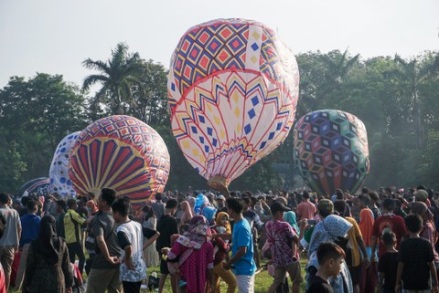 Sejumlah warga menerbangkan balon udara yang ditambatkan di tanah saat "Balloon Attraction Pekalongan 2022" di Lapangan Mataram, Kota Pekalongan, Jawa Tengah, Minggu (8/5/2022). Foto: Harviyan Perdana Putra/Antara Foto