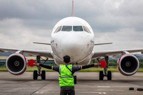 Seorang juru parkir pesawat (marshaller) memandu kedatangan pesawat yang mengangkut penumpang asal penerbangan Jakarta di area landasan parkir pesawat Bandara Internasional Jenderal Ahmad Yani Semarang, Jawa Tengah, Selasa (26/4/2022). Foto: Aji Styawan/ANTARA FOTO