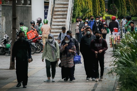 Pekerja berjalan sepulang kerja di kawasan Jalan Jenderal Sudirman, Jakarta, Rabu (2/2/2022).  Foto: Jamal Ramadhan/kumparan
