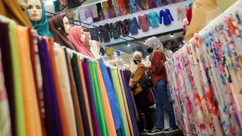 Calon pembeli melewati toko pakaian di salah satu pusat perbelanjaan di Malaysia.  Foto: Hasnoor Hussain/REUTERS