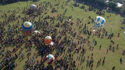 Foto udara sejumlah warga menerbangkan balon udara yang ditambatkan di tanah saat "Balloon Attraction Pekalongan 2022" di Lapangan Mataram, Kota Pekalongan, Jawa Tengah, Minggu (8/5/2022). Foto: Harviyan Perdana Putra/Antara Foto