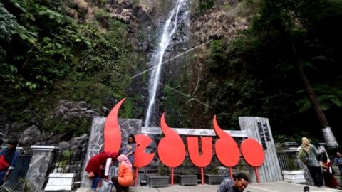 Wisatawan di air terjun Sedudo di Desa Ngliman, Kecamatan Sawahan, Kabupaten Nganjuk, Jawa Timur. Foto: Prasetia Fauzani/ANTARA FOTO