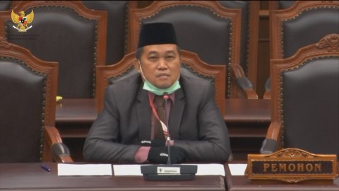 Boyamin Saiman membacakan gugatan dalam sidang pendahuluan gugatan Perppu Penanganan COVID-19 di Mahkamah Konstitusi, Selasa (28/4). Foto: Youtube/ Mahkamah Konstitusi RI